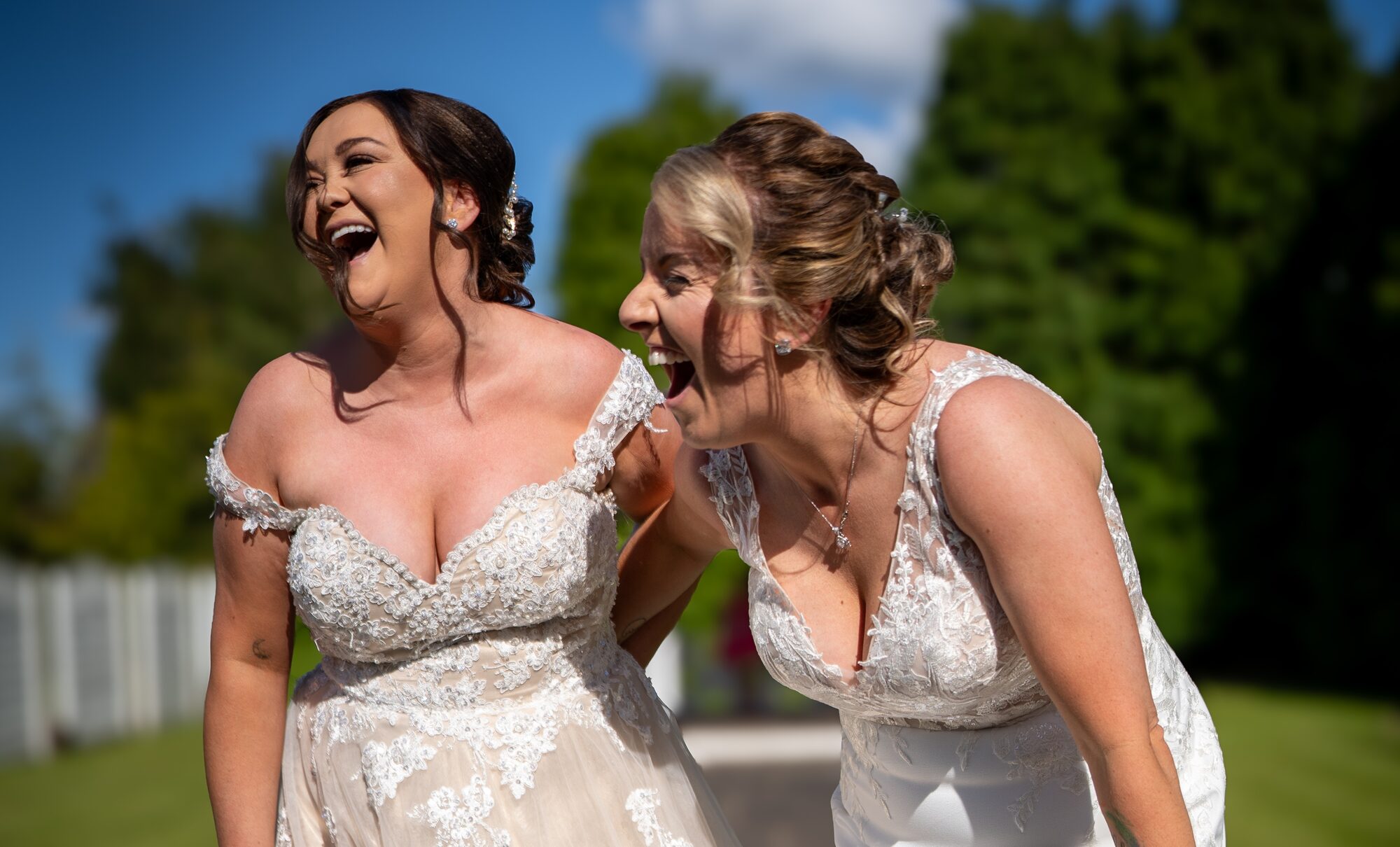 Two brides laughing outdoors